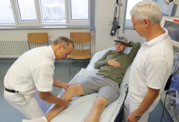 Sportorthopäde Dr. med. Uwe Flötgen (links) und Unfallchirurg Dr. med. Bernhard Karich untersuchen gemeinsam den Kreuzbandriss von FSV-Spieler Kevin Bönisch.