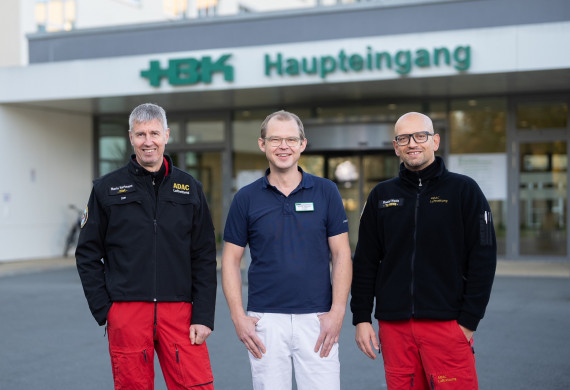 Prof. Dr. med. Andreas Wolfgang Reske zusammen mit Mario Hartmann, Pilot des Christoph 46 (links) und Daniel Wallis, Leitender TC HEMS Christoph 46 (rechts im Bild)